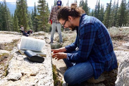 Geology student in nature studying a large rock formation