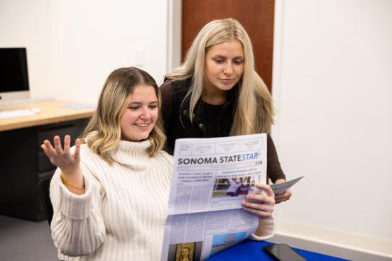 Two students reviewing the latest copy of the Sonoma State Star newspaper
