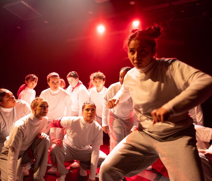 Performers wearing white dancing under red light