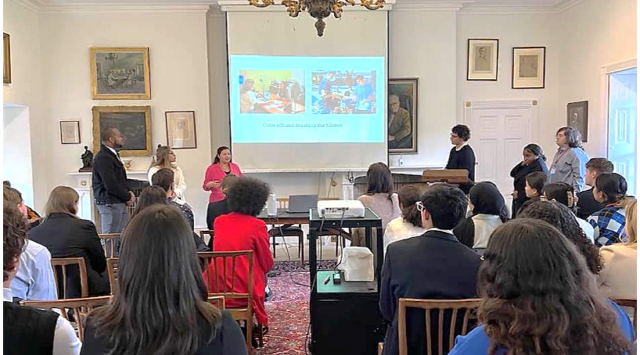 Students standing at the front of a room presenting to an audience