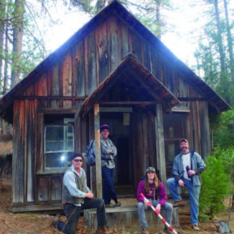 Four people sitting on the porch of building in Malakoff Diggins State Historic Park