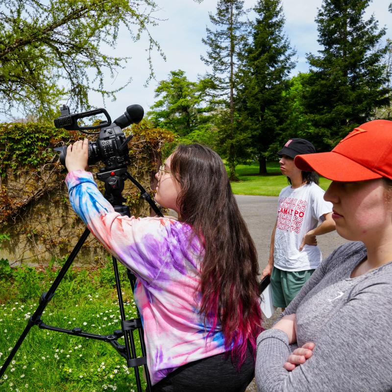 Students standing behind camera