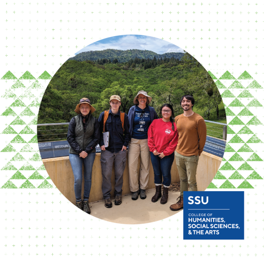 Group smiling in front of forest landscape